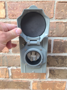 A hand inspecting an outdoor RV or generator electrical outlet by Joe Does It-Electrical Services in Atlanta, GA.
