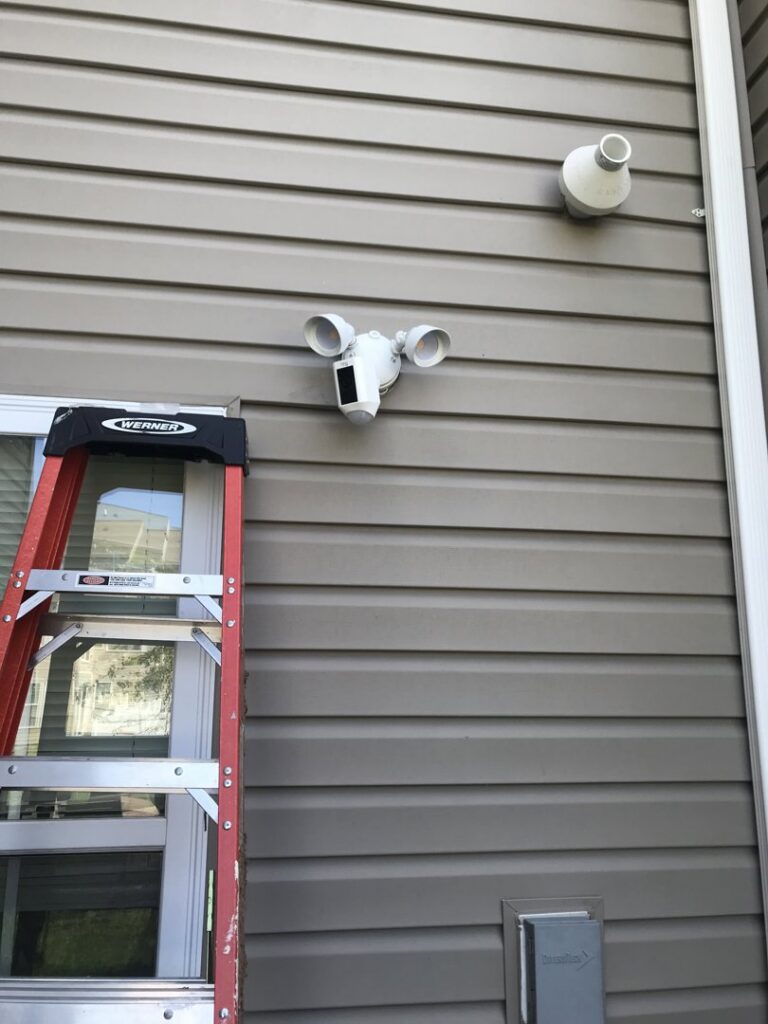 An outdoor security floodlight installed on house siding by GBE. Lectrical LLC in Gaithersburg, MD