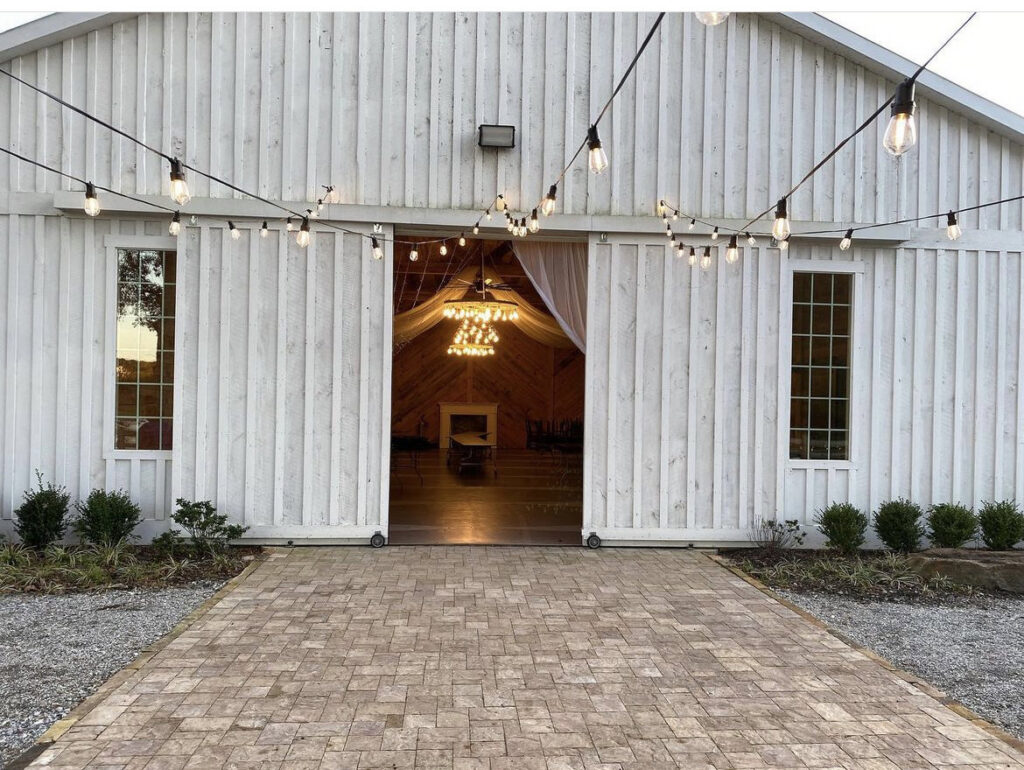 Outdoor string lights installed on a white barn building by E-Systems Electrical Inc. in Cumming, GA.