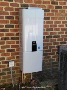 An outdoor tankless water heater installed on a brick wall next to an HVAC unit by Cannon Heating and Air Conditioning, LLC in Newport News, VA.