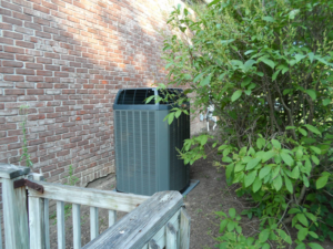 An outdoor Trane AC unit installed next to a brick wall by Extreme Heating and Cooling II - Indiana in Westfield, IN.