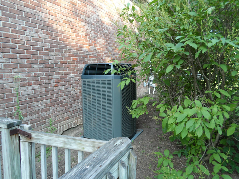An outdoor Trane AC unit installed next to a brick wall by Extreme Heating and Cooling II - Indiana in Westfield, IN.