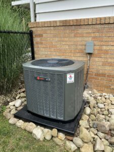 An outdoor Trane HVAC unit recently installed next to a brick wall by PureAir HVAC in Bel Air, MD.