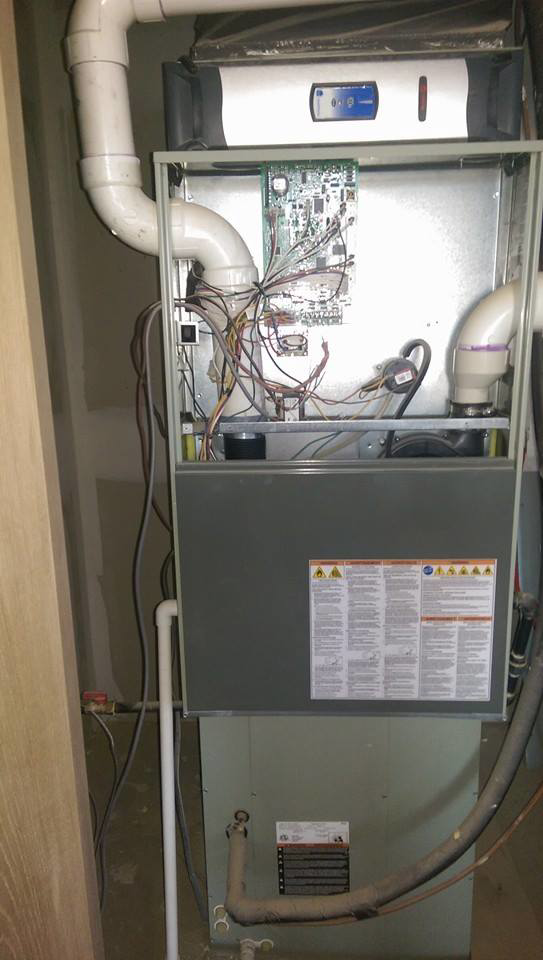 An outdoor Trane XV20 HVAC unit installed on risers next to a residential building by Stevens Refrigeration & Heating in Enid, OK