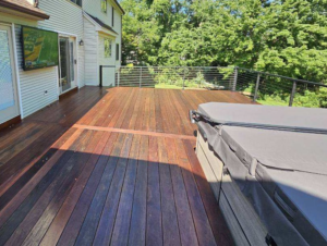 An outdoor TV mounted on a house wall above a deck, installed by EPOS Systems, Inc. in West Springfield, MA.