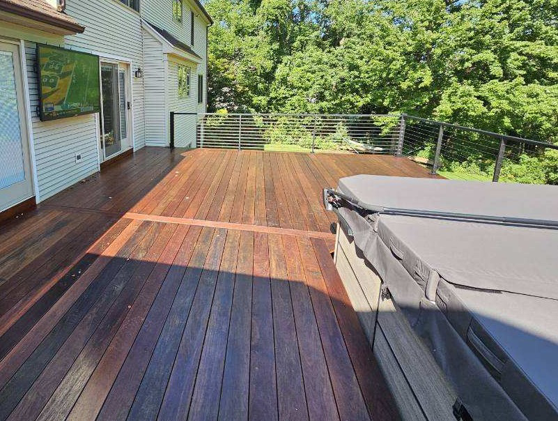 An outdoor TV mounted on a house wall above a deck, installed by EPOS Systems, Inc. in West Springfield, MA.