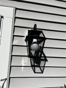 An outdoor wall lantern with an LED bulb installed on house siding by Richard Sullivan Licensed Electrician in Brockton, MA.