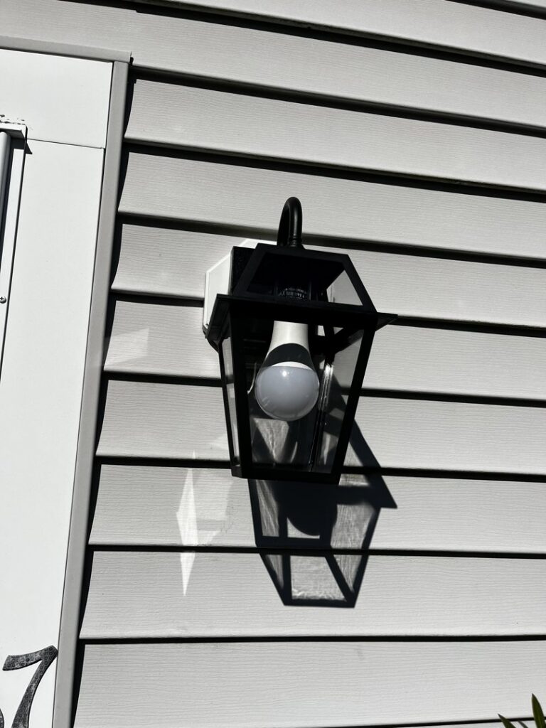 An outdoor wall lantern with an LED bulb installed on house siding by Richard Sullivan Licensed Electrician in Brockton, MA.