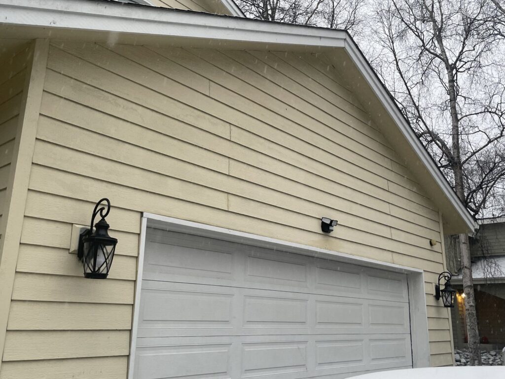 Exterior of a house with newly installed outdoor wall lights by Intel-electric in Anchorage, AK