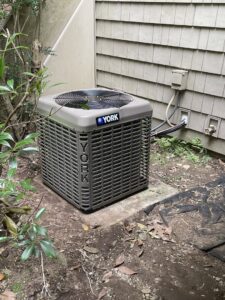 An outdoor YORK air conditioning unit installed next to a residential building by MTL Heating and Cooling LLC in West Haven, CT
