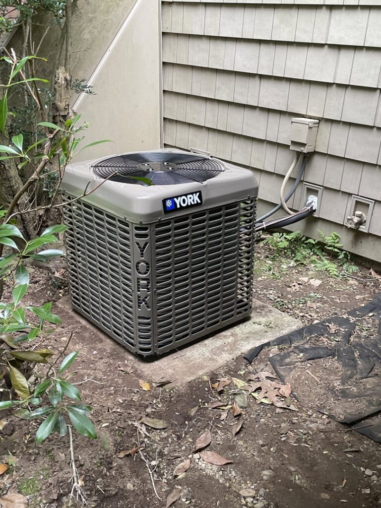 An outdoor YORK air conditioning unit installed next to a residential building by MTL Heating and Cooling LLC in West Haven, CT