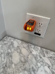 An outlet tester plugged into a wall outlet, indicating proper wiring during an electrical inspection by MCM Electrical Services LLC in Phoenix, AZ