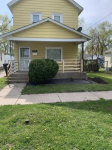 An overgrown bush in a front yard before trimming and landscaping work by Miguel Landscaping LLC in Janesville, WI.
