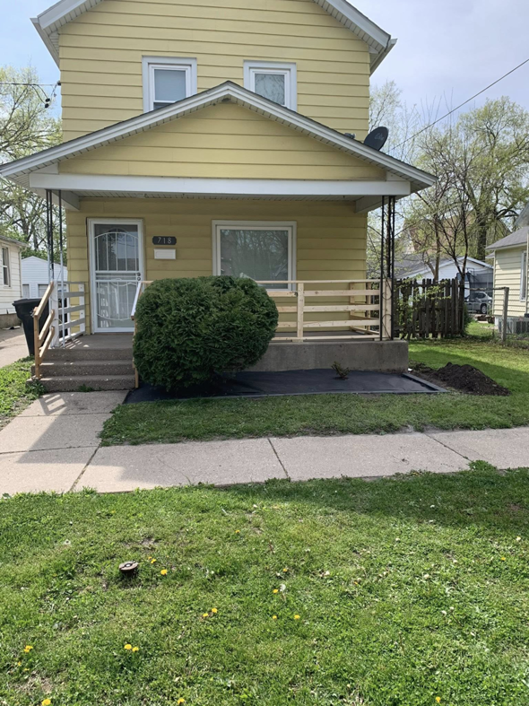 An overgrown bush in a front yard before trimming and landscaping work by Miguel Landscaping LLC in Janesville, WI.