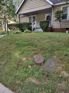An overgrown front yard of a house in Jackson, TN, clearly needing professional lawn care from Justice Lawn and Limbs.