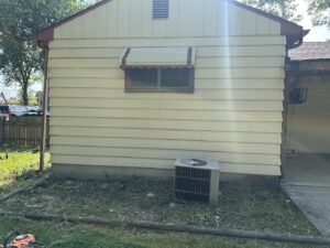 An area with overgrown weeds and grass around a house foundation, ready for service by Geno's Father & Son Lawn Services Llc in Hammond, IN