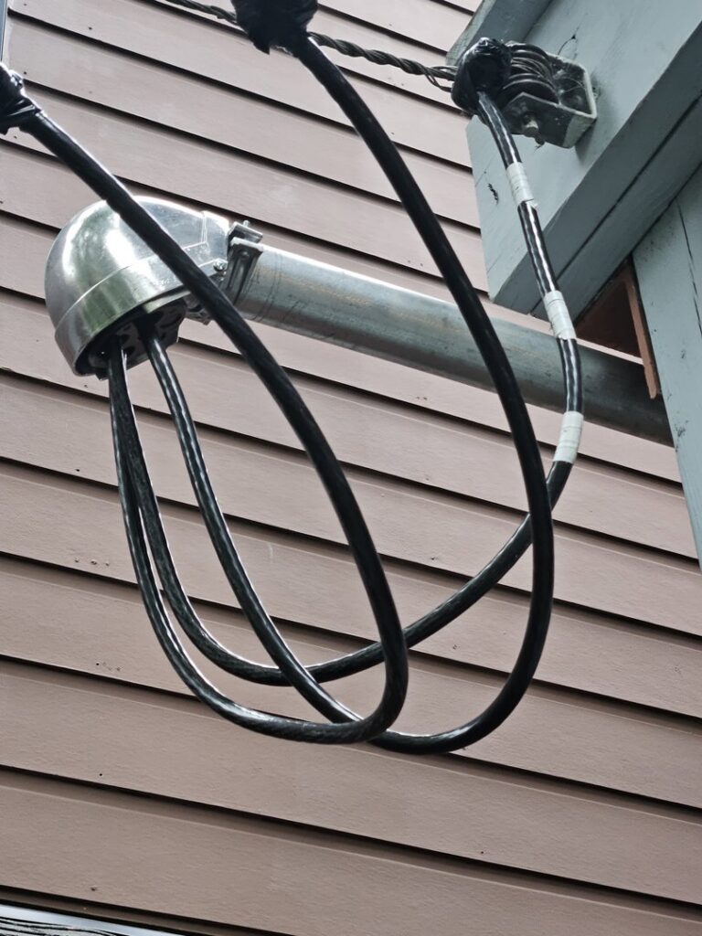 Overhead electrical service connection and conduit installation on a building by JAL Electrical Construction in Hammond, IN.
