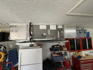An overhead HVAC system with air handler and ductwork installed in a garage by NextGen Aire of Southwest Florida in Punta Gorda, FL.