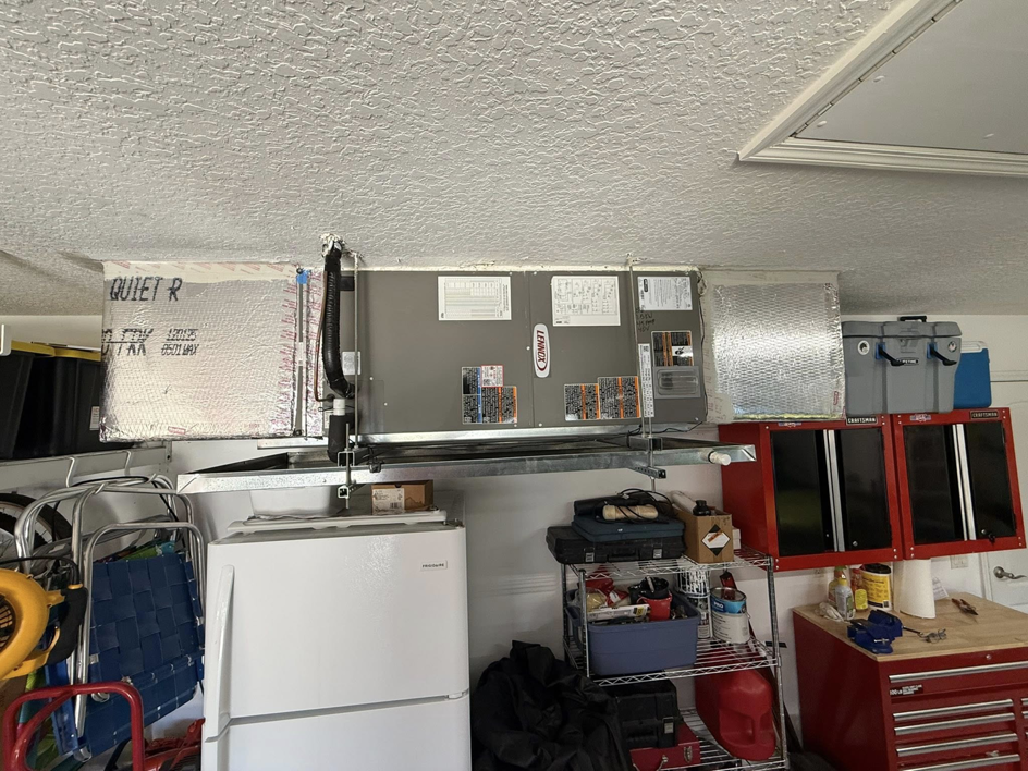 An overhead HVAC system with air handler and ductwork installed in a garage by NextGen Aire of Southwest Florida in Punta Gorda, FL.