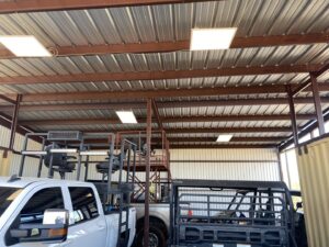 New overhead lighting installed in a large garage or workshop by Outlaw Home Services, LLC in San Antonio, Tx.