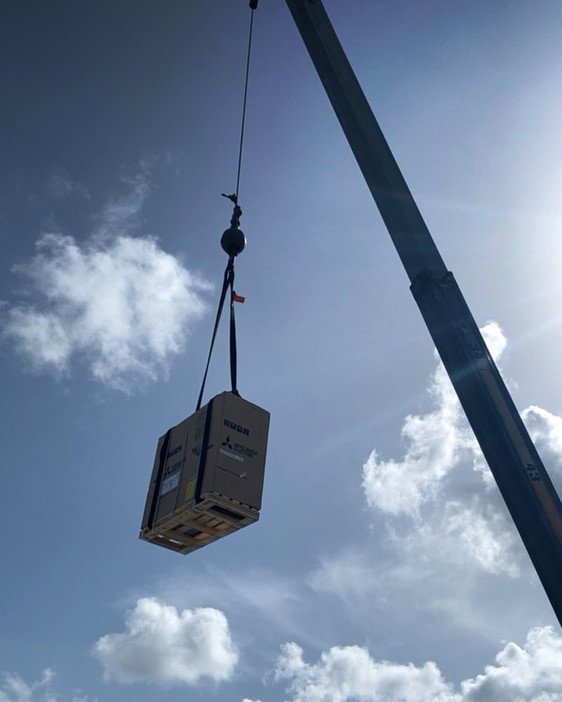 A packaged HVAC unit being lifted by a crane for installation by Uplifting Air, LLC in San Antonio, FL.