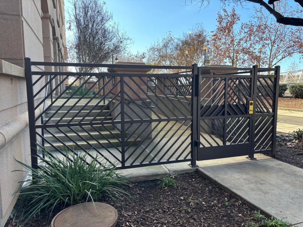 A stylish decorative metal gate and fence installed by Palmers Iron Fence at a commercial property in Sacramento, CA.