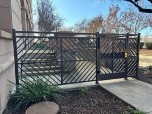 A stylish decorative metal gate and fence installed by Palmers Iron Fence at a commercial property in Sacramento, CA.