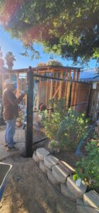 A Palmers Iron Fence worker installing a metal fence post, showcasing professional fence installation in Sacramento, CA.