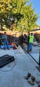 Palmers Iron Fence workers installing a new black metal fence, demonstrating their expertise in Sacramento, CA.