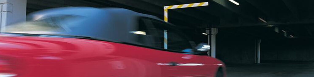 A car entering a parking garage with a barrier gate, installed by Access Hardware Inc in Honolulu, HI