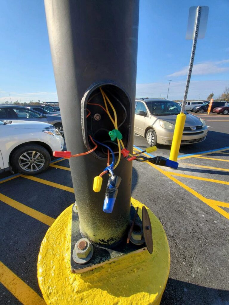 Exposed electrical wiring inside a parking lot light pole, showing repair work by Discount Electrical Service of Franklin in Franklin, TN