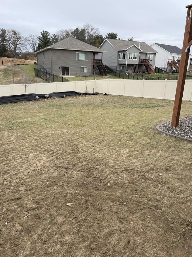 A partially installed white vinyl privacy fence in a residential backyard by Flash Fence in Phenix City, AL.