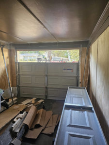 A white garage door partially installed inside a garage by The Garage Man in Memphis, TN.