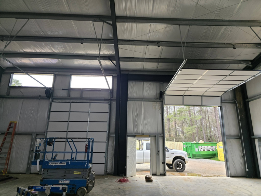 A partially open commercial garage door during installation by Coles Garage Door Service, LLC in West Columbia, SC.