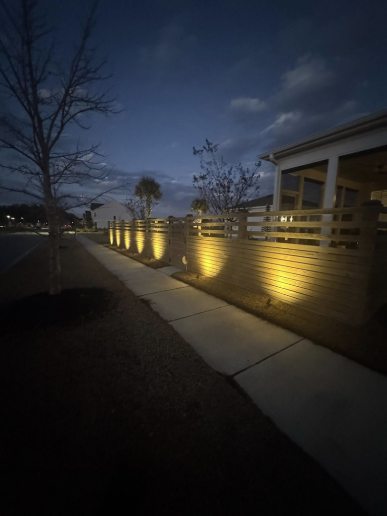 Pathway and fence lighting installed along a sidewalk, demonstrating electrical expertise by Watts Up Electric LLC in Summerville, SC.