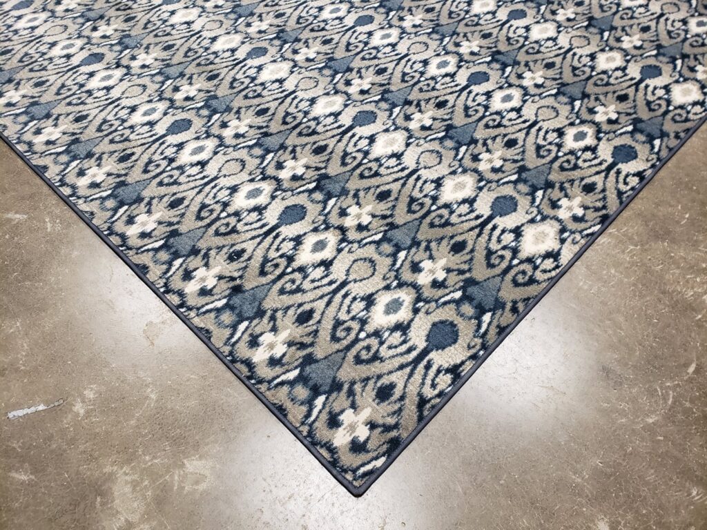 A patterned area rug with intricate blue and grey design and bound edges, a custom job by Carpet Binding By Scott in Oklahoma City, OK