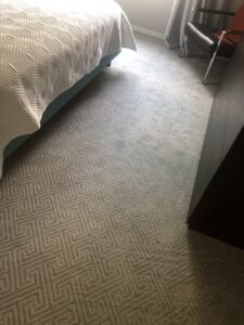 A close-up view of a bedroom with stylish patterned carpet, expertly installed by B A Carpet and Flooring in Broken Arrow, OK.