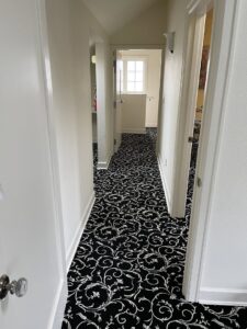 A hallway showcasing a newly installed black and white patterned carpet by Hatloes Carpet One Floor & Home in Everett, WA.