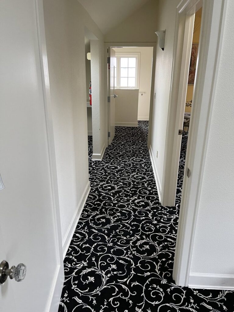A hallway showcasing a newly installed black and white patterned carpet by Hatloes Carpet One Floor & Home in Everett, WA.