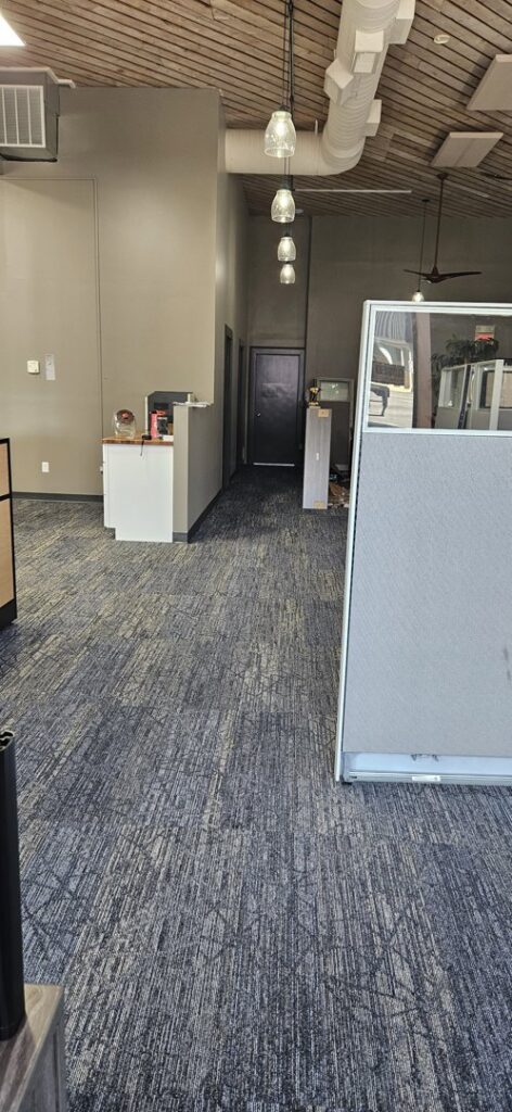 A view of newly installed patterned carpet in an office space near a window by Carpet Warehouse in Lafayette, IN.