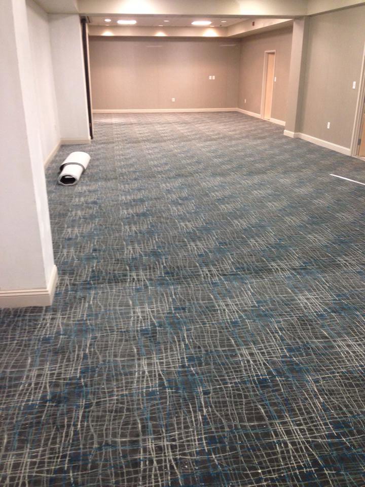 Patterned carpet being installed in a large room by Saraceno & Sons, a carpet contractor in Allentown, PA.