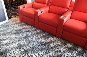 A room with red recliners and a newly installed patterned carpet by Floors For Living - Meyerland in Houston, TX.