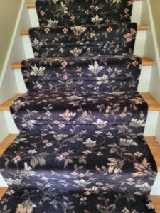 A beautifully installed patterned carpet runner on wooden stairs by Greenco2, a carpet contractor in Grand Rapids, MI.