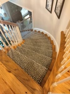 A beautifully installed patterned carpet runner on a wooden staircase by Adda Carpet and Flooring in New Orleans, LA.