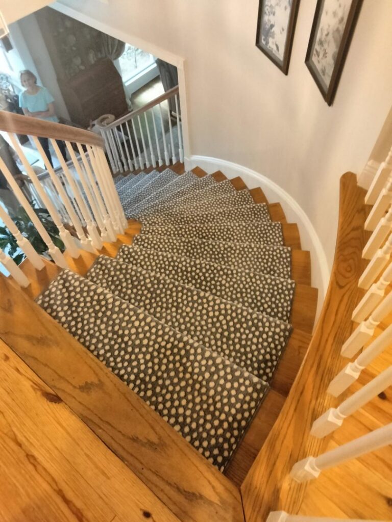 A beautifully installed patterned carpet runner on a wooden staircase by Adda Carpet and Flooring in New Orleans, LA.