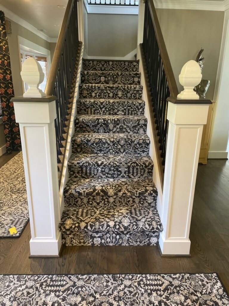 A beautifully installed patterned carpet runner on a staircase by Marion's Carpet & Flooring Warehouses in Portland, OR.