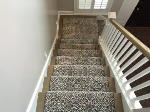A decorative patterned carpet stair runner installed by The Carpet Workroom in Needham Heights, MA.