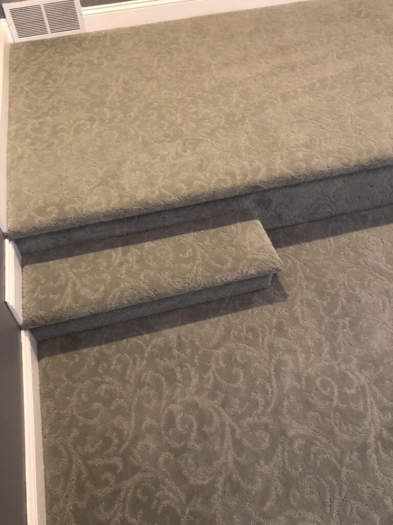 A close-up view of a staircase with newly installed patterned carpet by Grand Rapids Flooring in Grand Rapids, MI.