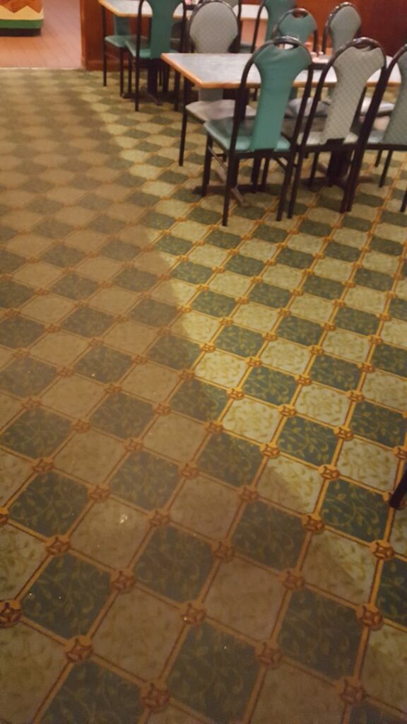 Patterned commercial carpet cleaning in a restaurant, showing a clean and dirty section, by Keith's Cleaning Service in Auburn, ME