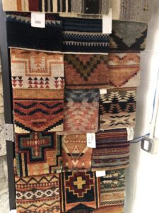 A close-up of various patterned rug samples hanging on display at Artifacts Fine Rugs and Flooring in South Salt Lake, UT.